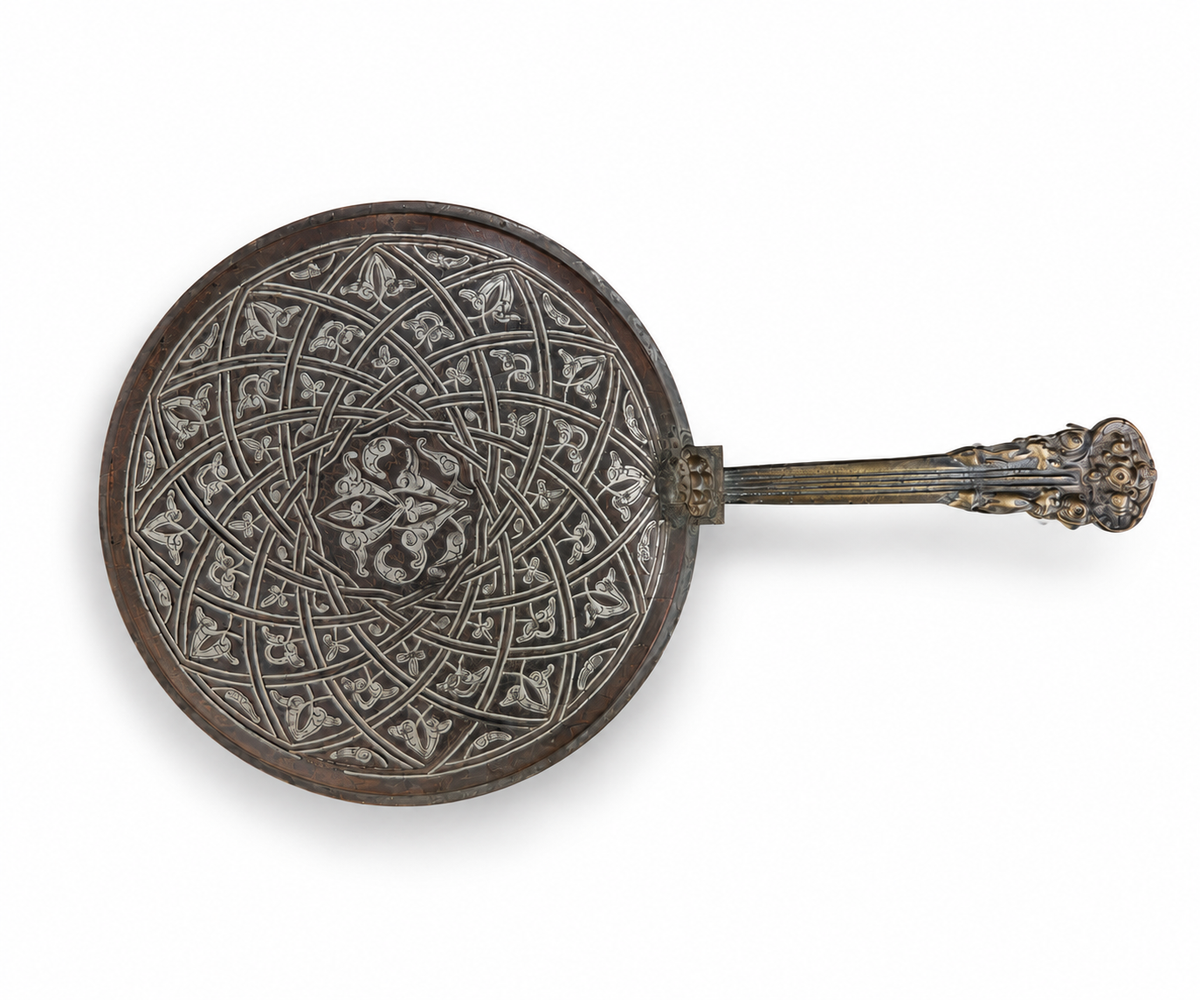 Islamic copper hand mirror front view showing silver-inlaid girih arabesque pattern
