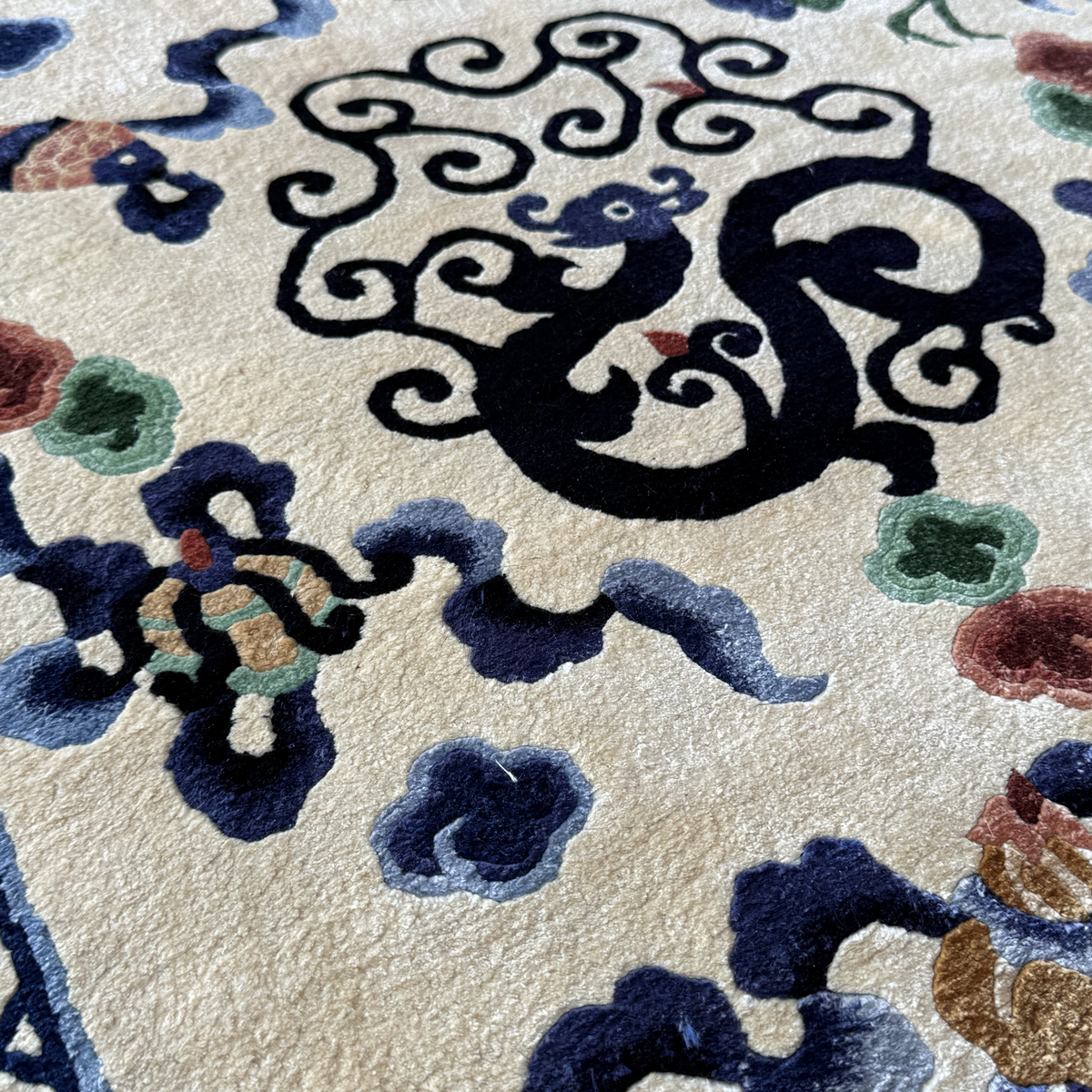 Close-up detail of dragon and cloud motifs on Tianjin silk carpet