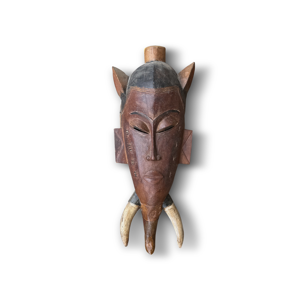 Guro Baule African tribal mask front – hand-carved hardwood with animal horns, incised markings, domed dark cap and wooden finial