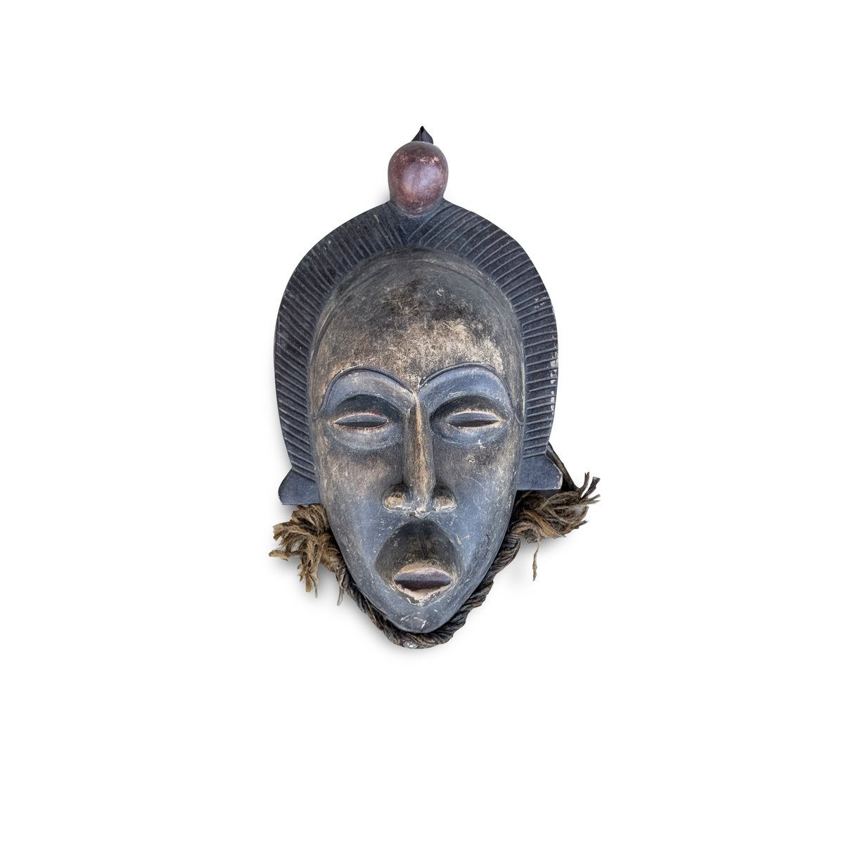 Chokwe-style African tribal mask, hand-carved hardwood with dark blue-grey patina, ribbed arched crest, spherical finial, and natural fiber attachments